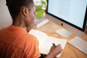 Mulher negra escrevendo em um caderno